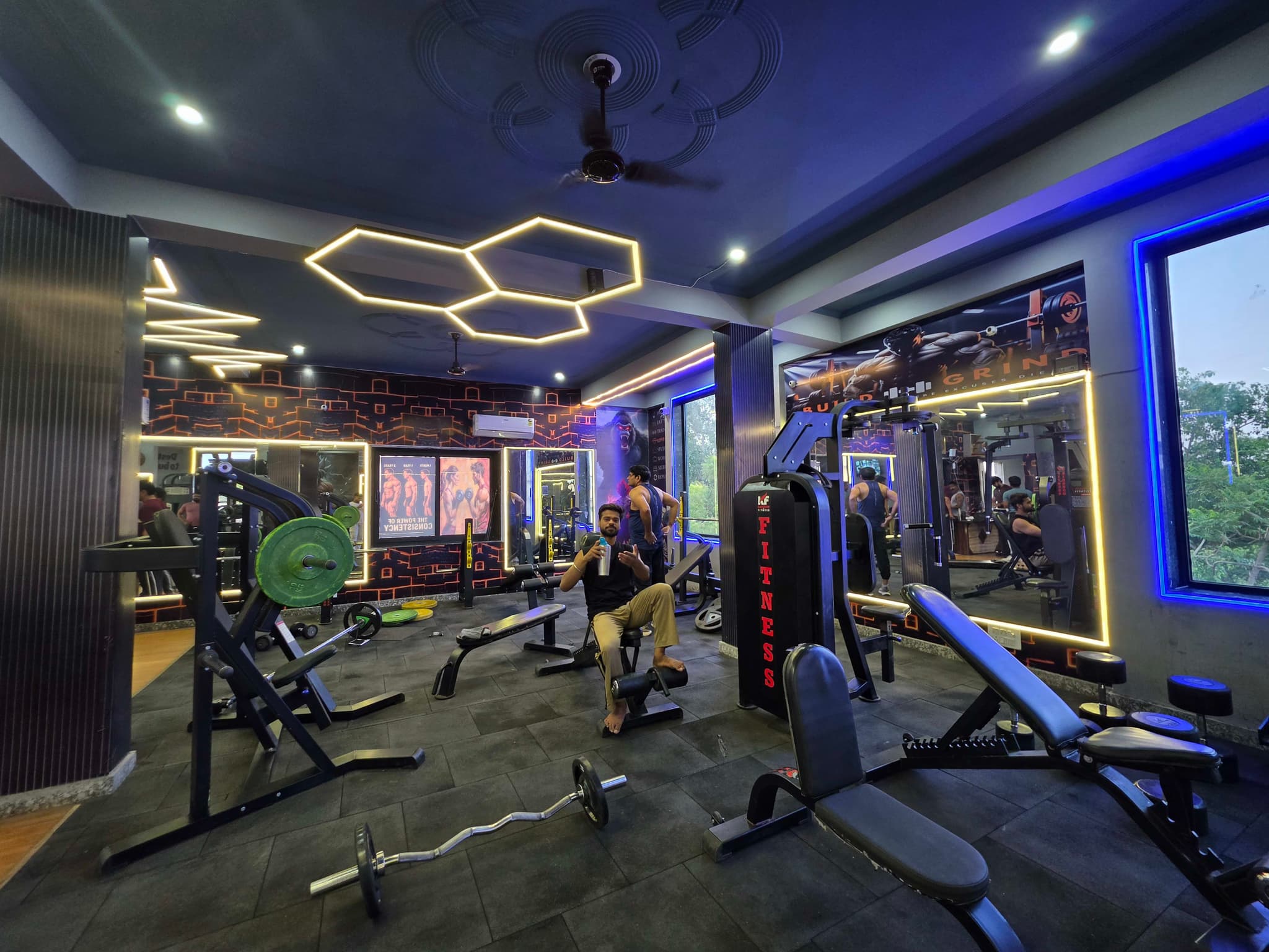 Wide view of the training floor with hexagon ceiling lighting and cable machines at G2 Fitness Club