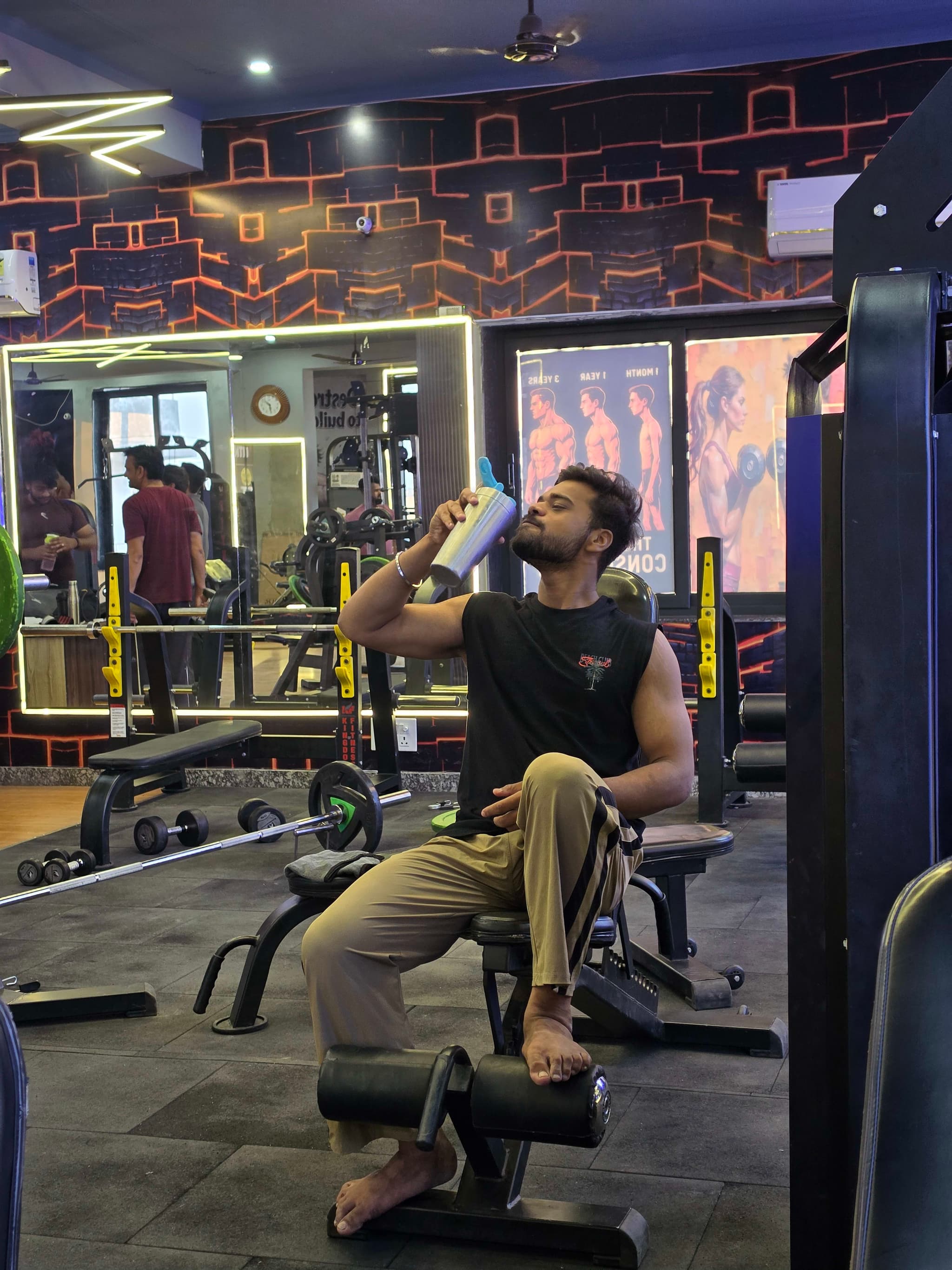 Member resting between sets with a protein shaker on the training floor at G2 Fitness Club